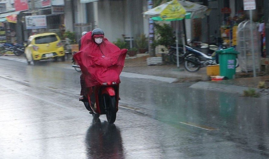 Người dân đi lại trong mưa lớn. Ảnh: Nguyên Lý