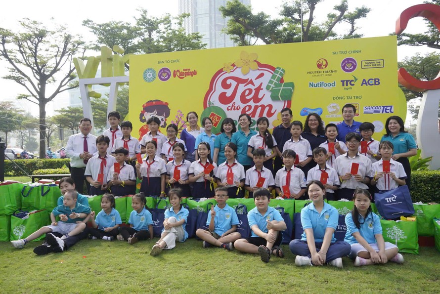 Ông Trần Hữu Đức, Trưởng phòng CSR (áo trắng, ngoài cùng bên trái), đại diện công ty Nutifood trao quà Tết cho trẻ em khó khăn tại chương trình