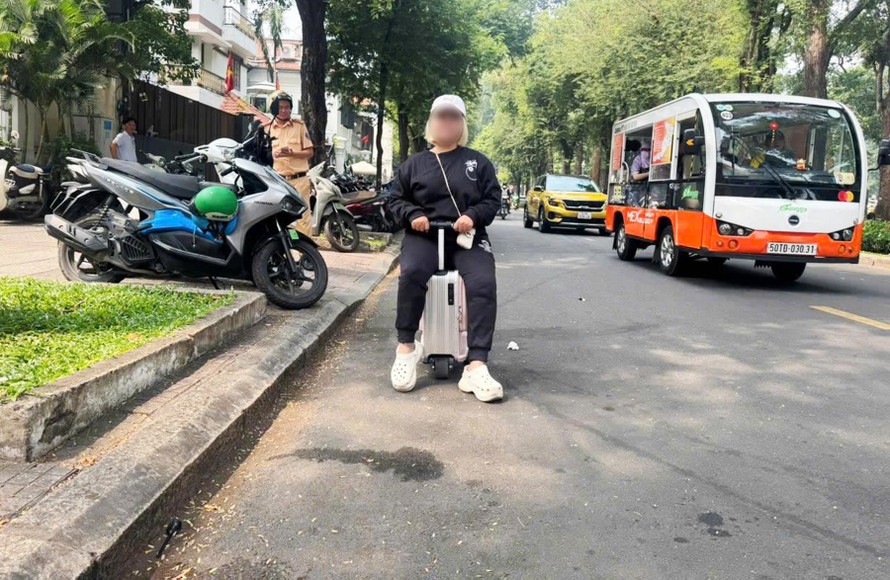 Bà T. cưỡi vali đi trên đường Lê Duẫn bị lực lượng CSGT phát hiện xử phạt.
