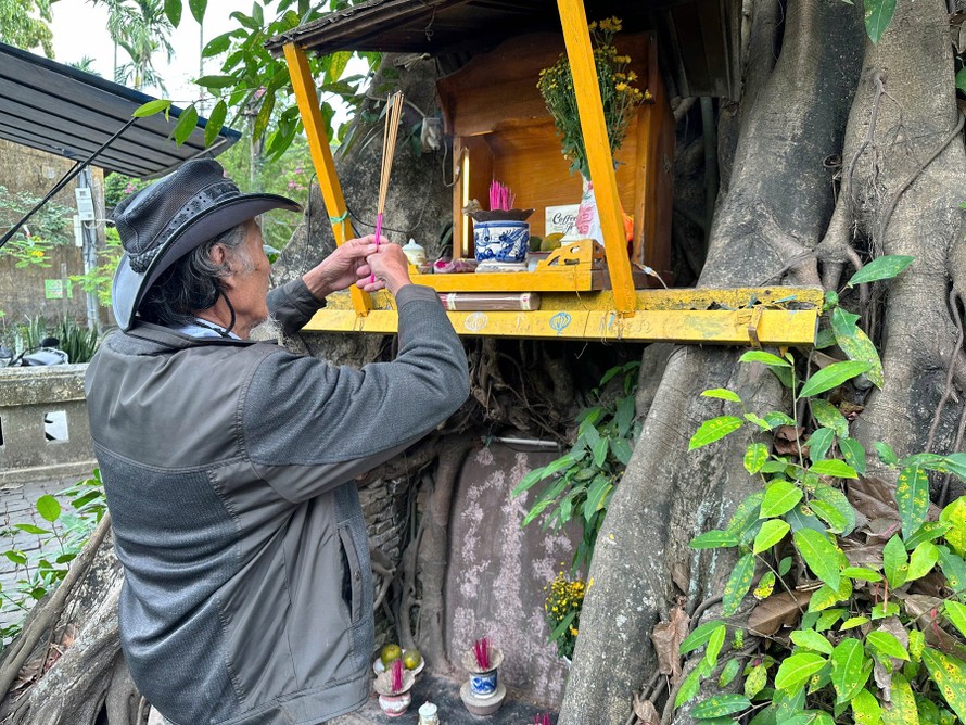 Ông Sáu Lợi ngày ngày dọn dẹp, thắp nhang trước bia cổ dưới gốc cổ thụ. 
