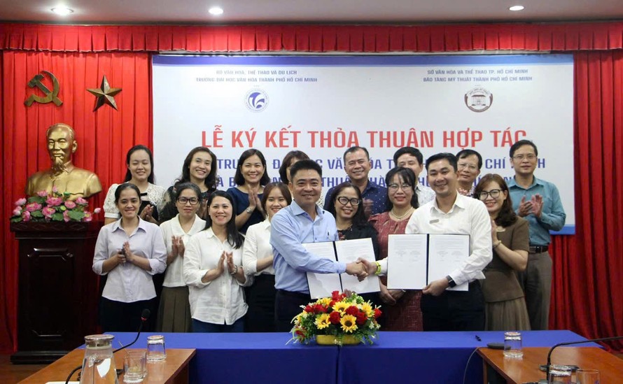 Phó giáo sư, tiến sĩ Lâm Nhân – Hiệu trưởng Đại học Văn hóa TP.HCM (bên trái) và ông Trần Minh Công – Phó Giám đốc phụ trách Bảo tàng Mỹ thuật TP.HCM trao bản thỏa thuận hợp tác