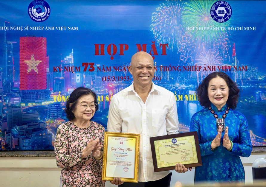 Nguyên Phó Chủ tịch nước Trương Mỹ Hoa (bìa trái) chúc mừng NSNA Nguyễn Á nhận tước hiệu Nghệ sĩ Nhiếp ảnh đặc biệt xuất sắc (E.VAPA/G)