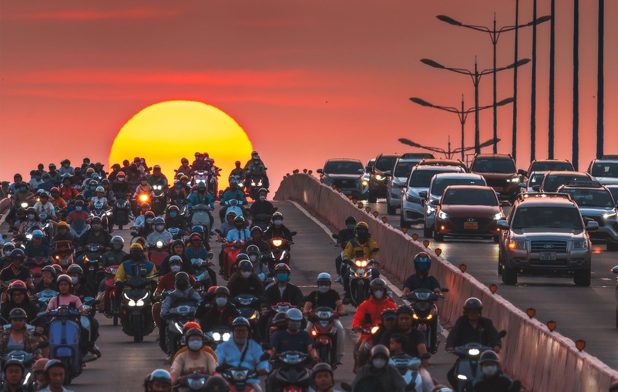 Khoảnh khắc dòng xe cộ lăn bánh xuyên qua vầng mặt trời đang lặn xuống tại chân cầu Sài Gòn (TPHCM) do tác giả Phúc Lê chụp