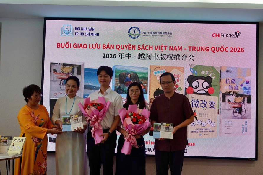 Dịch giả Nguyễn Lệ Chi (trái) tặng hoa và sách cho các đối tác