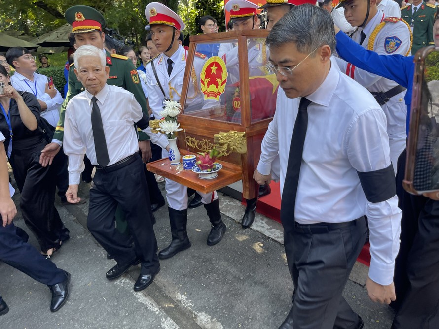 Thủ tướng Lê Minh Hưng và nguyên Chủ tịch nước Nguyễn Minh Triết cùng di quan hài cốt liệt sĩ ra xe về nơi an nghỉ cuối cùng. Ảnh: Hoàng Nhân