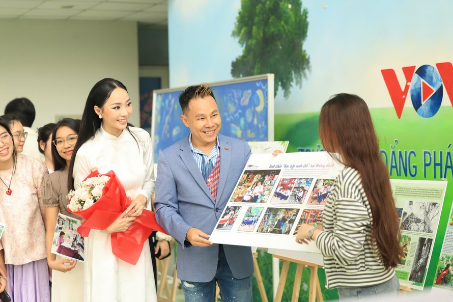 Hoa hậu Miss Charm Vietnam 2026 Nguyễn Ngọc Trà My (áo dài) thích thú xem ảnh chủ đề “Tắt điện thoại, mở sách ra” của sinh viên Trường CĐ Phát thanh - Truyền hình II. Ảnh: Nguyễn Đặng Thanh Ngân