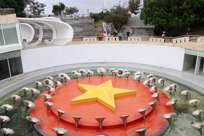 Hồ nước “Vòng tròn bất tử” thiêng liêng tại Khu tưởng niệm chiến sỹ Gạc Ma ở xã Cam Hải Đông, huyện Cam Lâm, tỉnh Khánh Hòa với 64 đóa hoa, tượng trưng cho 64 người con anh dũng cùng ôm lấy lá cờ đỏ sao vàng nổi trên mặt nước. Ảnh: Hữu Quyết/TTXVN.