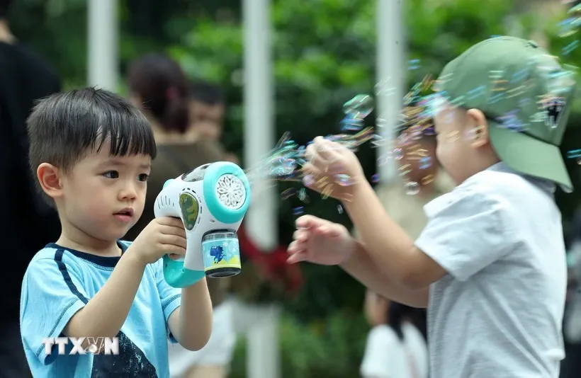 Các bạn nhỏ vui đùa tại phố đi bộ hồ Hoàn Kiếm. Ảnh: Quốc Khánh/TTXVN.