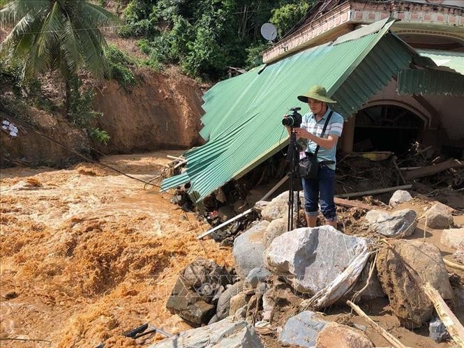 Phóng viên Cơ quan thường trú TTXVN tại Nghệ An Nguyễn Văn Tý ghi hình lũ quét tại huyện Kỳ Sơn (Nghệ An), tháng 10/2022. Ảnh: TTXVN.