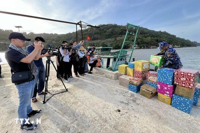 Phóng viên tác nghiệp trong chuyến công tác thăm, chúc tết cán bộ, chiến sỹ nhân dân và các lực lượng trên vùng biển Tây Nam. Ảnh: TTXVN.