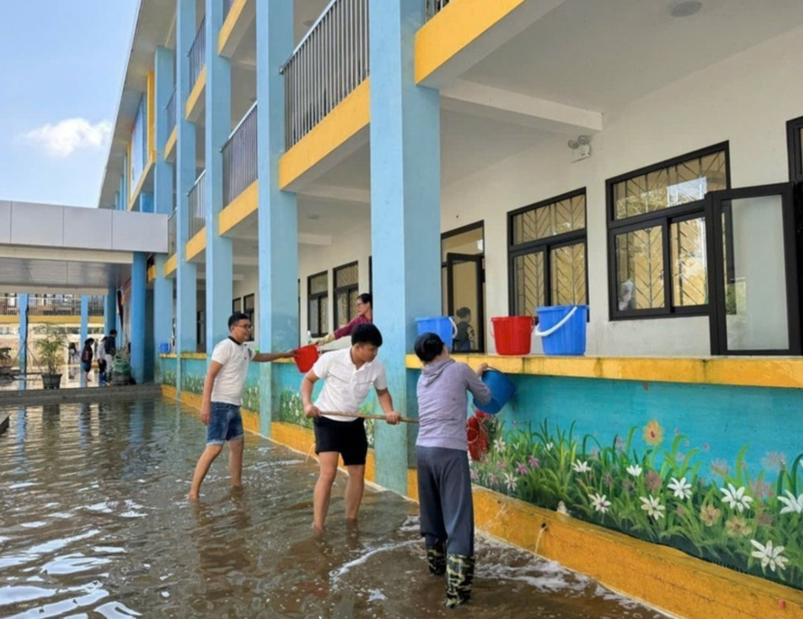 Giáo viên, nhân viên Trường Trung học Cơ sở Nam Phương Tiến A dọn vệ sinh trường lớp sau nhiều ngày bị ngập sâu. Ảnh: Nguyễn Cúc