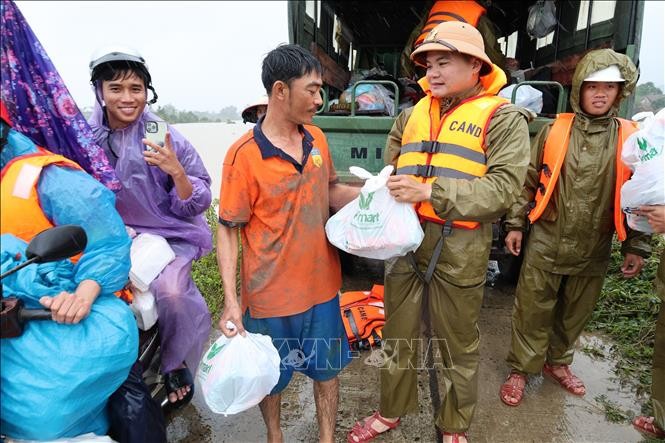 Lực lượng Công an tỉnh Đắk Lắk gửi tặng phần quà cho người dân ở vùng bị ngập sâu do nước lũ. Ảnh: Đỗ Trưởng/TTXVN.