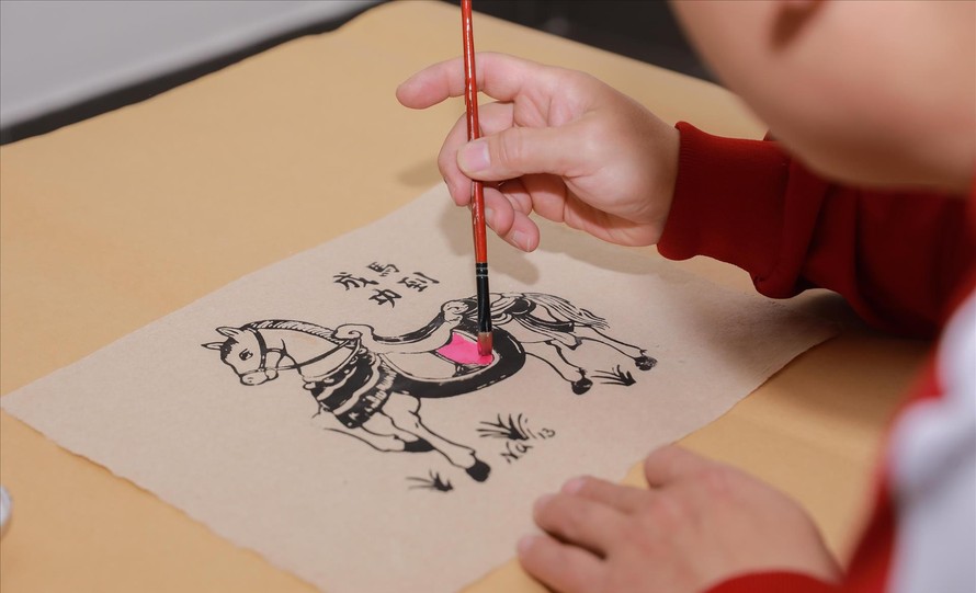 Du khách được trải nghiệm in tranh tại triển lãm. Ảnh: Phan Phương/TTXVN.