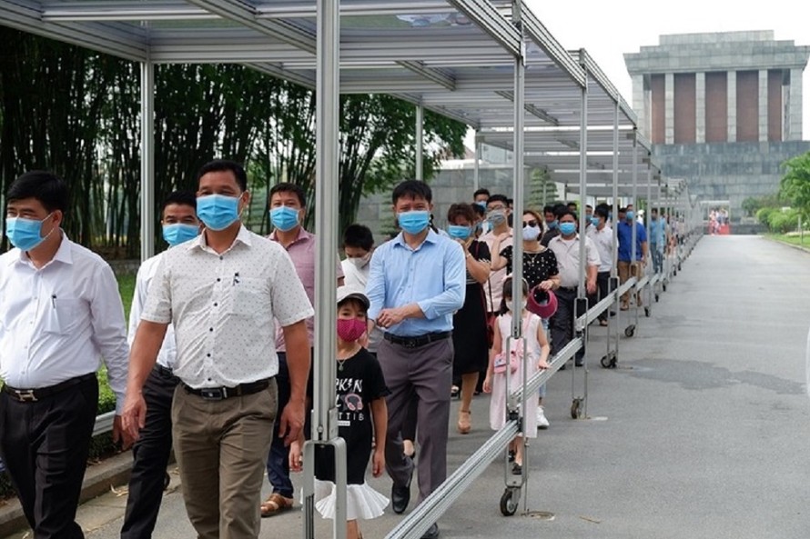 Du khách xếp hàng tham quan từ Lăng Chủ tịch Hồ Chí Minh. Buổi chiều khi Lăng đóng cửa, việc kiểm tra thân nhiệt sẽ được thực hiện ở cổng vào khu di tích Phủ Chủ tịch.