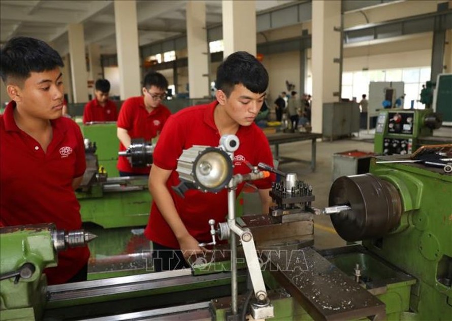 Học sinh lớp cao đẳng cắt gọt kim loại hệ 9+ K12 thực hành trên máy tiện vạn năng. 