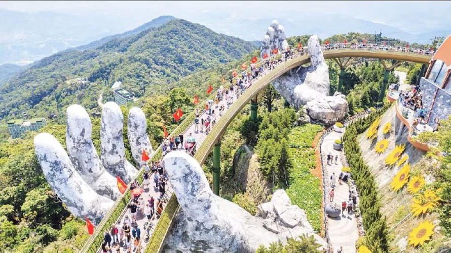 Du khách thưởng lãm khung cảnh công trình "Cầu Vàng" rợp bóng cờ đỏ sao vàng.