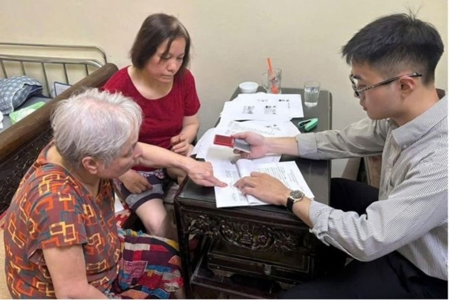 Thành viên Tổ xung kích hành chính công điểm Ô Chợ Dừa - Chi nhánh số 3 hỗ trợ người dân. 