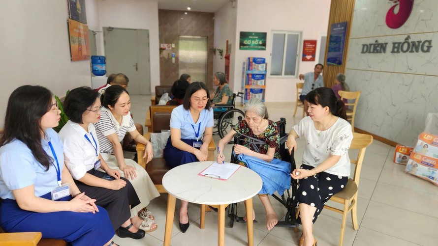 Cán bộ Trung tâm Phục vụ hành chính công Hà Nội xuống cơ sở giúp người yếu thế hoàn thiện thủ tục chi trả lương hưu.