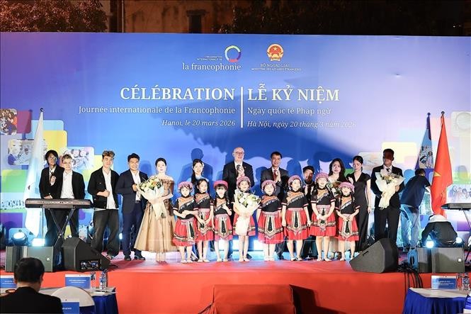 Ông Đặng Hoàng Giang, Thứ trưởng Bộ Ngoại giao và ông Pierre Du Ville, Trưởng đại diện Phái đoàn Wallonie-Bruxelles tại Việt Nam chụp ảnh lưu niệm với các bạn trẻ tham gia biểu diễn văn nghệ. Ảnh: Phạm Tuấn Anh