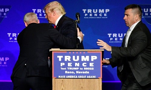 Ứng viên tổng thống đảng Cộng hòa Donald Trump được nhân viên an ninh hộ tống rời sân khấu trong sự kiện vận động ở bang Nevada ngày 5/11 khi nghi có mối đe dọa từ đám đông phía dưới. Ảnh: Reuters.