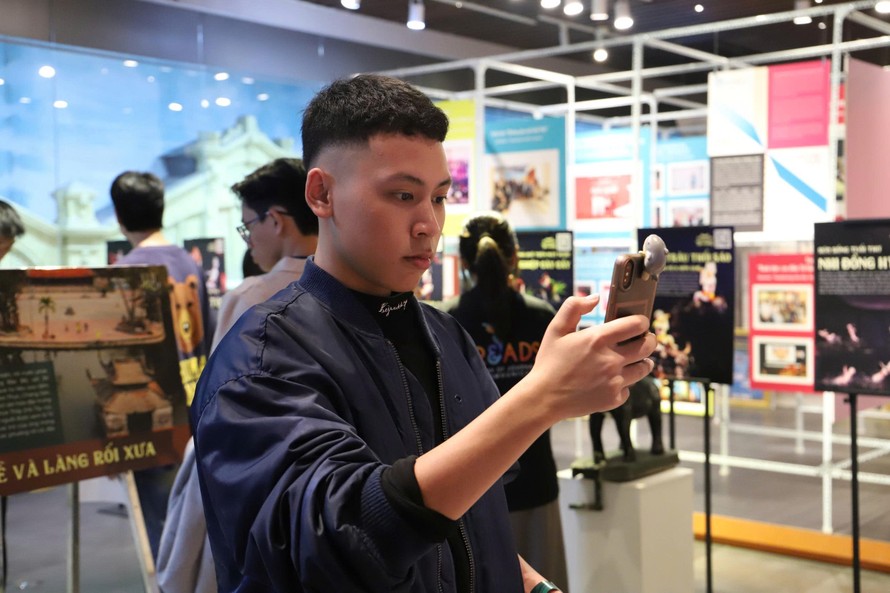 Khách tham quan trải nghiệm các tích trò rối nước bằng công nghệ AR tại triển lãm