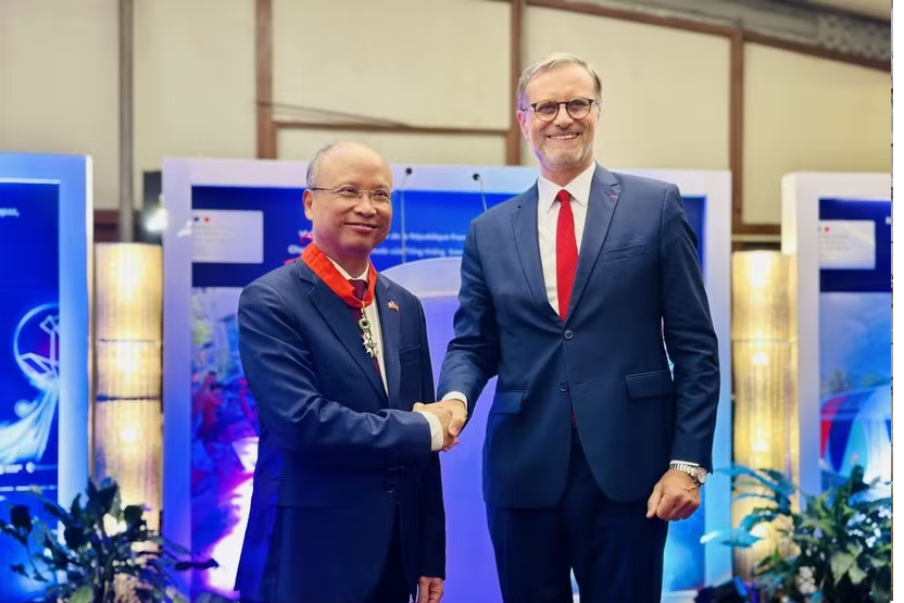 Thừa ủy quyền của Tổng thống Cộng hòa Pháp, Đại sứ Pháp tại Việt Nam Olivier Brochet trân trọng trao Huân chương Bắc đẩu Bội tinh tặng Đại sứ Đinh Toàn Thắng. (Ảnh: Việt Đức/TTXVN)