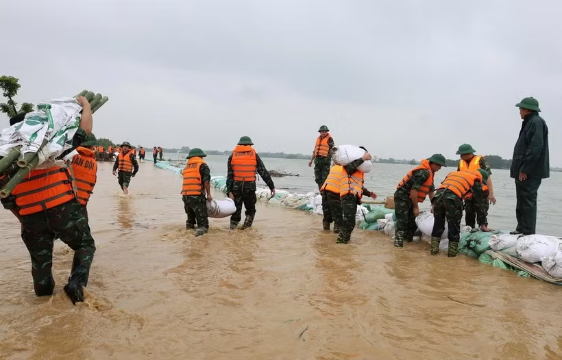 Các chiến sỹ thuộc tiểu đoàn 3 Lữ đoàn xe tăng 201 đắp các đoạn đê trũng, thấp trên tuyến đê Bùi 2. (Ảnh: Nguyễn Cúc/TTXVN)