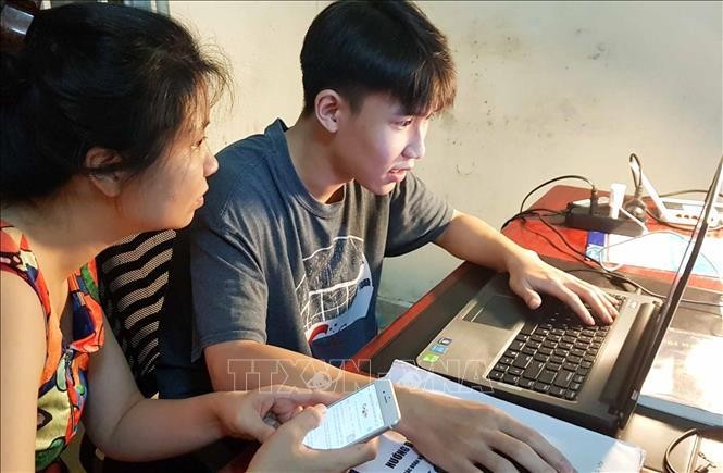 Thí sinh và phụ huynh cùng tra cứu điểm thi trên mạng ngay sau thời gian Bộ Giáo dục và Đào tạo công bố điểm. Ảnh: TTXVN