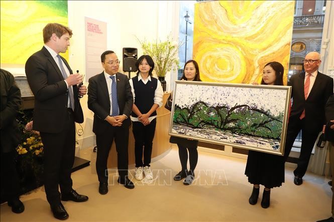 Họa sĩ Xèo Chu tặng bức tranh cho Thái Tử Charles. Ảnh: Vân Hải/Pv TTXVN tại London