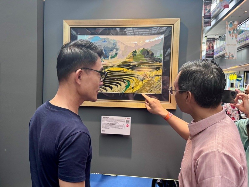 Đại sứ Trần Phước Anh (phải) giới thiệu tranh của Việt Nam với ông Baey Yam Keng - Quận trưởng quận Đông Bắc. 