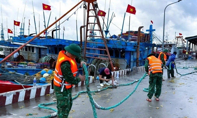 Cán bộ, chiến sỹ Đồn Biên phòng cửa khẩu cảng Cửa Lò - Bến Thuỷ (Bộ đội Biên phòng tỉnh Nghệ An) hỗ trợ ngư dân thu dọn ngư lưới cụ.