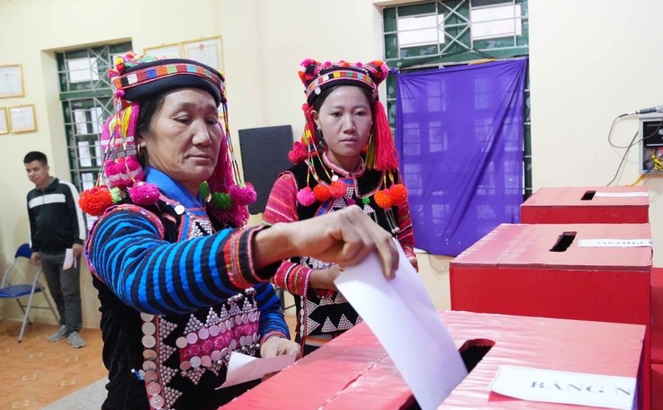 Đồng bào dân tộc Hà Nhì trong trang phục rực rỡ bỏ phiếu tại Tổ bầu cử số 1, xã Sín Thầu.